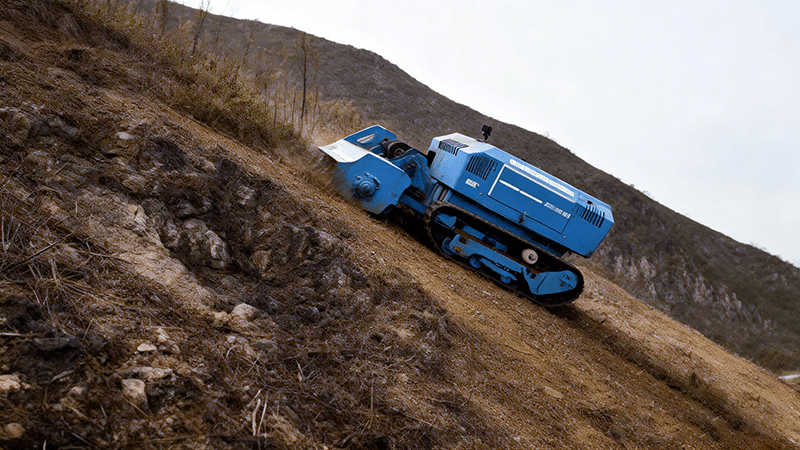 smart tracked land clearing machine on steep hillside